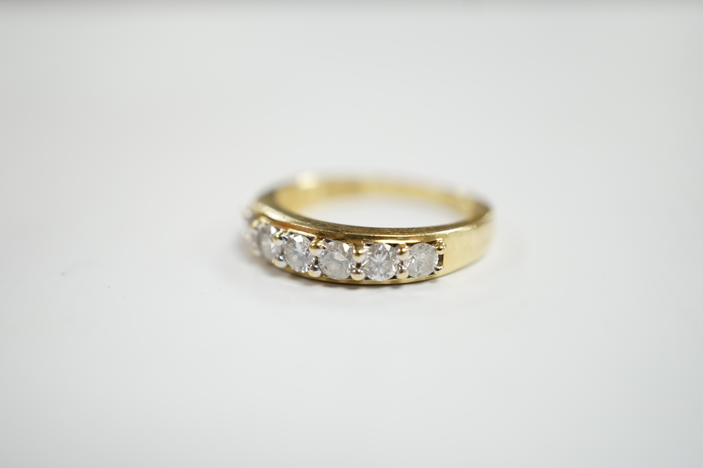 A modern 18ct gold and seven stone diamond set half hoop ring, size N, gross weight 4 grams.